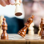 Close-up of a chess game with a focused player, emphasizing strategy and competition.